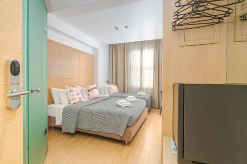 un dormitorio con una cama y un televisor de pantalla plana en Chic Hotel, en Atenas