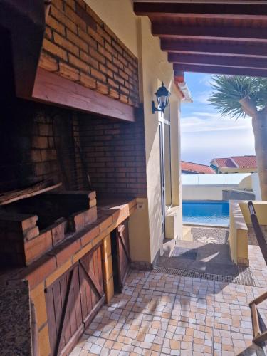 a house with a patio with a view of a pool at Basilio's Villa in Funchal
