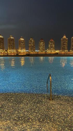 a large body of water with a city in the background at Luxurious Apartment in The Pearl, Qatar in Doha