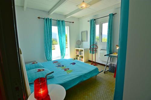 a bedroom with a blue bed and a window at Maison Capanelli in Casa delle Torre