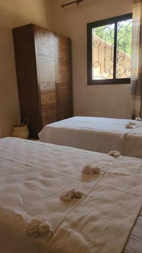 a bedroom with two beds and a window at Villa des tortues 3 Marrakech piscine privative sans vis à vis in Marrakech