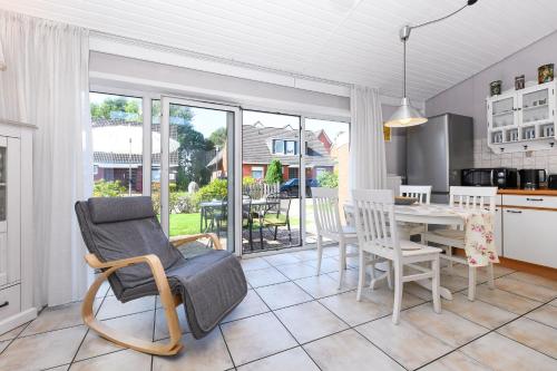 ベンサージールにあるFerienhaus Luv und Leeのテーブルと椅子のあるキッチンとダイニングルーム