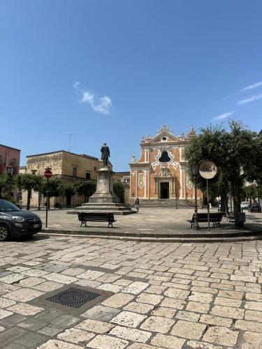 a building with a statue in the middle of a plaza at Le Stanze di Lucia vicino Ospedale Cardinale Panico a Tricase in Tricase