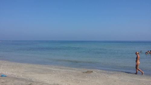 a woman walking on the beach near the water at Villa Maria House in Torre rinalda