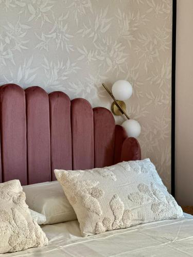 a bed with a red headboard and a pillow at Golden Palm B&B in Bari