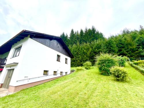 a white house with a black roof and a yard at Forestside Raceway Hideaway in Oberweg