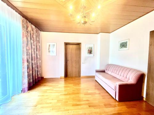 a living room with a couch and a wooden floor at Forestside Raceway Hideaway in Oberweg