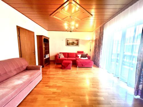 a living room with a red couch and a table at Forestside Raceway Hideaway in Oberweg