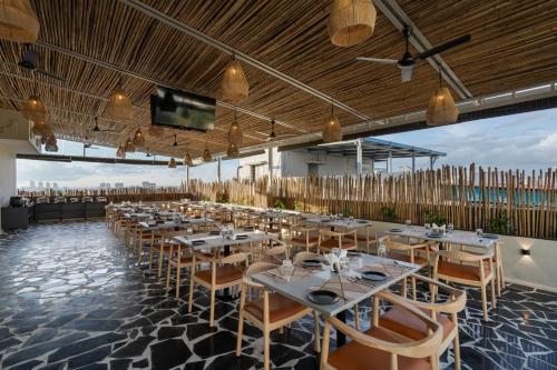 a dining room with tables and chairs and a flat screen tv at Fressotel, Kanakapura Road in Bengaluru
