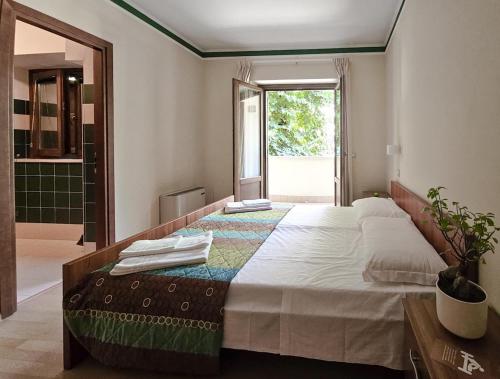 a bedroom with a large bed and a window at Fanesia coliving in Fano Adriano