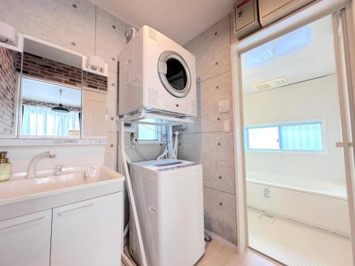 a small bathroom with a sink and a washing machine at グランディオーソ沖縄ヴィラ恩納1 in Onna