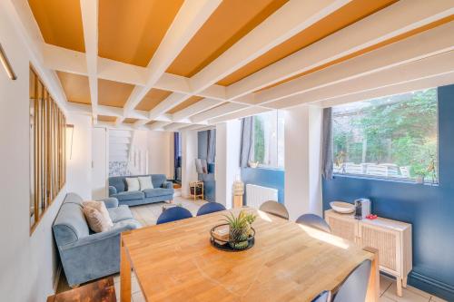 d'un salon avec des murs bleus et une table en bois. dans l'établissement MONTMARTRE Sacré-Coeur, appartement jardin 6 à 8P, à Paris