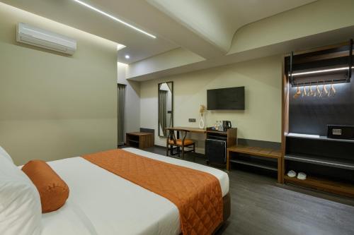 a hotel room with a bed and a desk at Fressotel, Kanakapura Road in Bengaluru