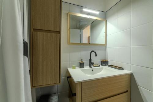 une salle de bain avec un lavabo et un miroir dans l'établissement Appart T2 à 5 min Parc Tete d'or - Parking privé, à Villeurbanne