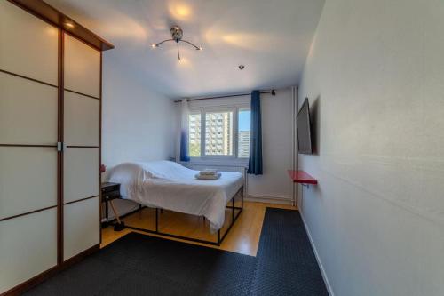 une petite pièce avec un lit et une fenêtre dans l'établissement Appart T2 à 5 min Parc Tete d'or - Parking privé, à Villeurbanne