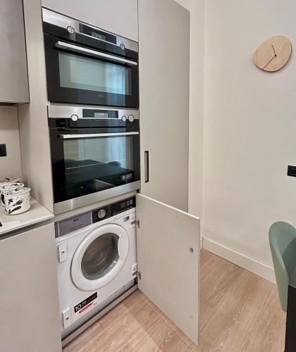 a kitchen with a washing machine and a microwave at Guli's Suite - Lusso e Comfort in Centro Storico in Naples