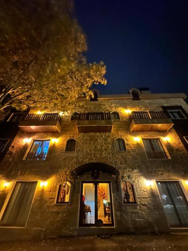 an old stone building with lights on it at night at Rokwood faraya in Ash Sha‘rah