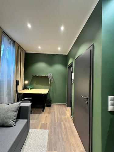 a living room with green walls and a couch and a table at Stilvolle und moderne Wohnung in Kierspe
