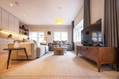a living room with a couch and a tv at Luxurious 2 bed flat in Covent Garden in London