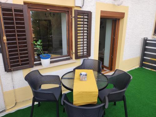 a patio with a table and chairs and a window at Ellena Sunshine in Opatija