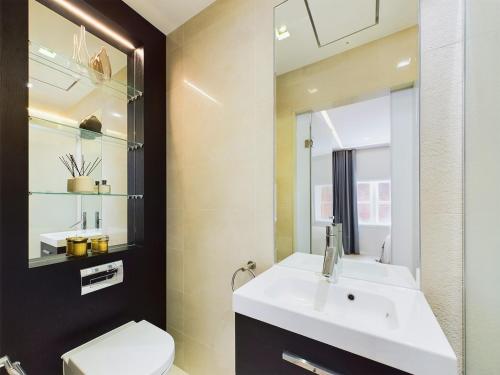 a bathroom with a sink and a toilet and a mirror at Luxurious 2 bed flat in Covent Garden in London