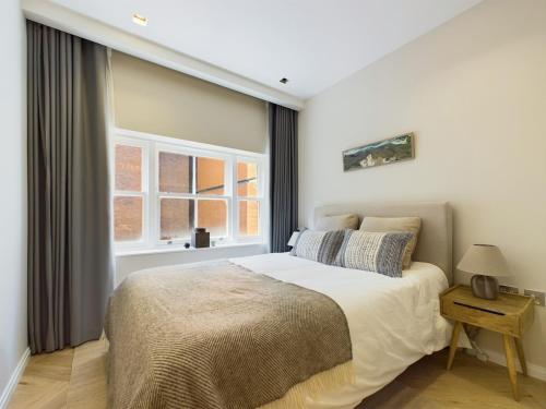 a bedroom with a large bed and a window at Luxurious 2 bed flat in Covent Garden in London