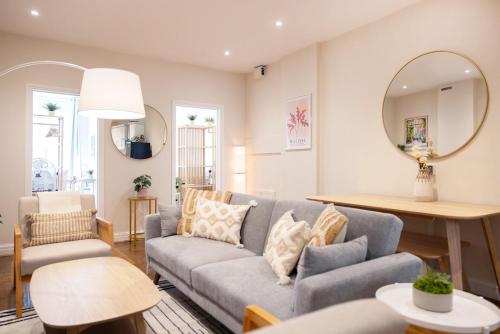 a living room with a couch and a table and a mirror at Two-Bed City Centre flat 100m from Trafalgar sqr in London