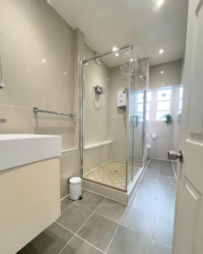 a bathroom with a shower with a glass door at Two-Bed City Centre flat 100m from Trafalgar sqr in London