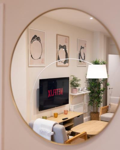 a mirror reflection of a living room with a tv at Two-Bed City Centre flat 100m from Trafalgar sqr in London