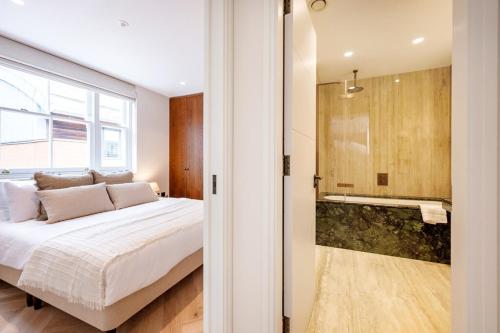 a bedroom with a large bed and a shower at Covent Garden 2 bed 2 bath duplex in London