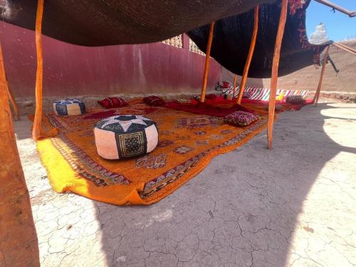 a table with a blanket on top of a tent at Gite d'étape Tafsoute in Tameskikt