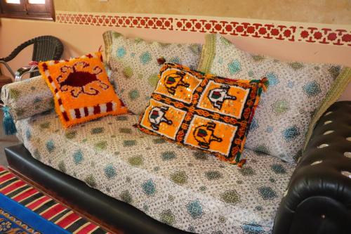 a couch with pillows on top of it at Gite d'étape Tafsoute in Tameskikt