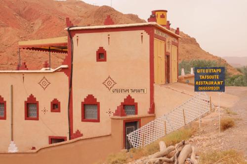a building in the desert with a sign on it at Gite d'étape Tafsoute in Tameskikt