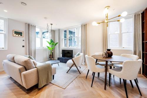 a living room with a table and chairs at Two Bed Duplex in Covent Garden in London