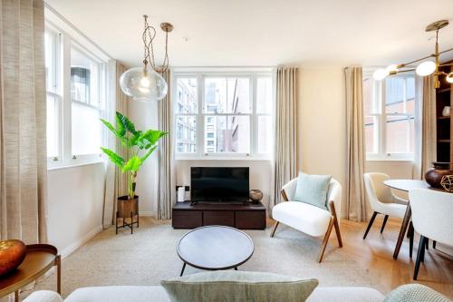 a living room with a couch and a tv at Two Bed Duplex in Covent Garden in London