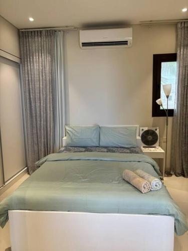 a bedroom with a large bed with blue sheets at Hawana Salalah Resort - Acacia 51 in Ma‘mūrah