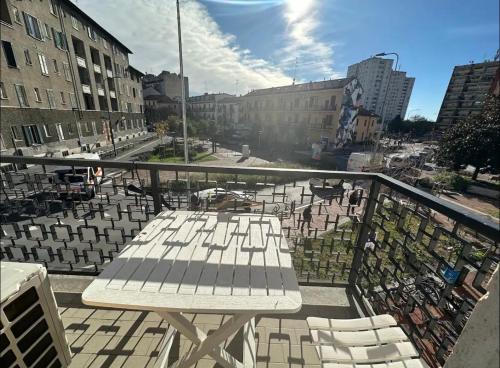 a balcony with a table and chairs on a city street at Gigli, rooms con cucina in comune e terrazza in Milan