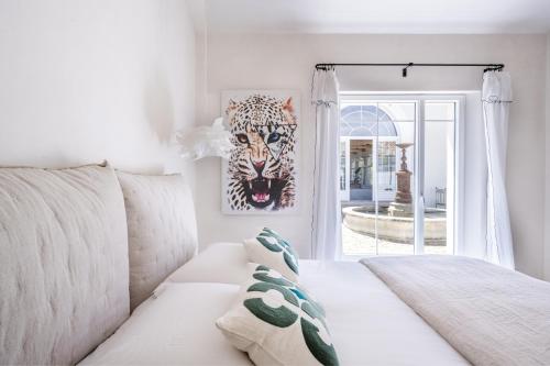 a living room with a white couch and a tiger mask at Secret d'Uzès - Place aux Herbes - Piscine chauffée et Jacuzzi in Uzès