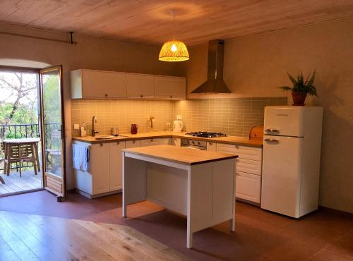 une cuisine avec un réfrigérateur blanc et une table dans l'établissement Appartement dans ancienne maison, à Rocles