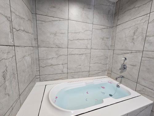 a white bath tub in a bathroom with marble walls at RiverView Tent Resort in Kevadia