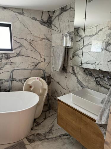 a bathroom with a white tub and a sink at Larnaca Centre Villa in Larnaka