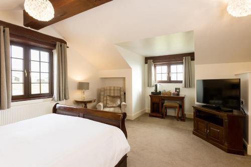 a bedroom with a bed and a flat screen tv at Pack Horse Inn - New Mills in Mellor
