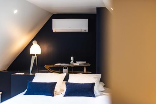 a bedroom with a white bed with blue pillows at La Sainthilarienne in Saint-Lary-Soulan