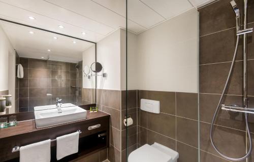 a bathroom with a sink and a shower at Wyndham Grand Salzburg Conference Centre in Salzburg
