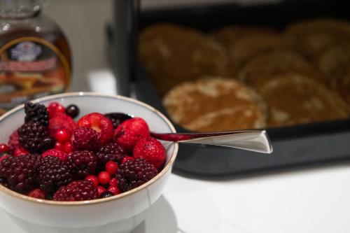 a bowl of berries sitting on a table with a spoon at Storm Hotel by Keahotels in Reykjavík