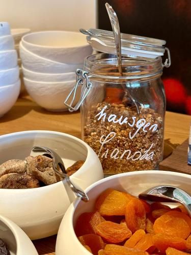 a table with two bowls of food and a jar of nuts at Fräulein Leni Hotel in Gamlitz