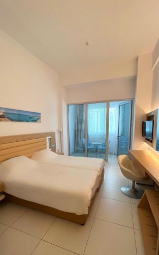 a hotel room with two beds and a television at Vrissaki Beach Hotel in Protaras