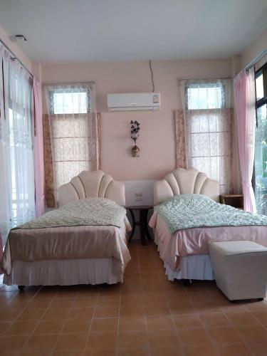 two beds in a room with pink walls and windows at Sawasdee House in Lamai