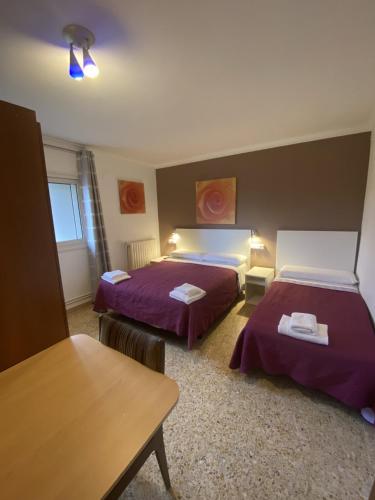 a hotel room with two beds and a table at Casa Les Roques in Báscara