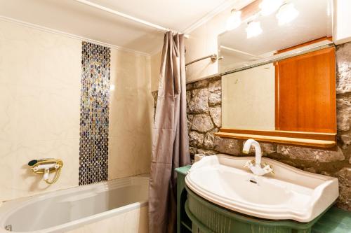 a bathroom with a sink and a bath tub at Seaside Dukes Villas in Paralion astros
